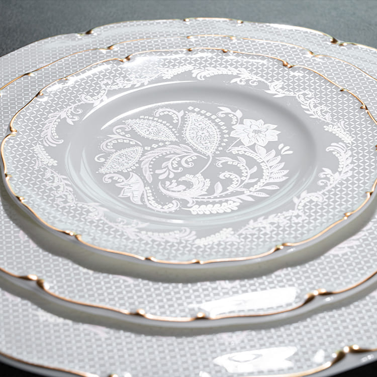 A close-up of bone china plates featuring delicate floral designs and elegant gold rims.