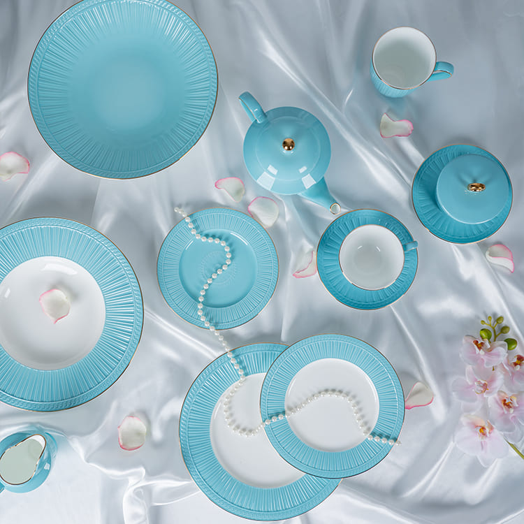 This image offers a top-down view of a blue bone china dinnerware collection, elegantly arranged on a white satin tablecloth.