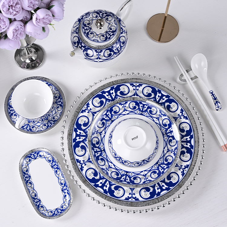 The set includes a teapot, cup, saucer, and various plates, each piece meticulously designed with intricate blue and white motifs that are both classic and contemporary.