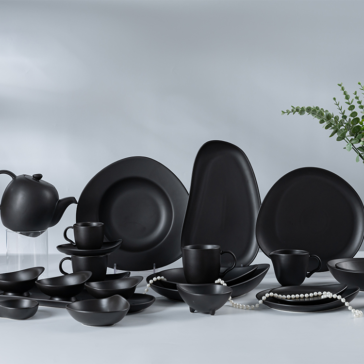This image showcases a comprehensive black porcelain tableware set, featuring an array of plates, bowls, cups, and a teapot, each piece crafted with precision and elegance.
