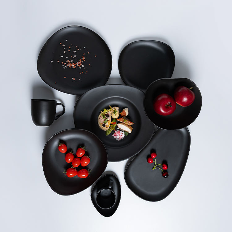 This image features a versatile collection of black porcelain dining pieces, including plates, bowls, and a mug, each showcasing a sleek, modern design.