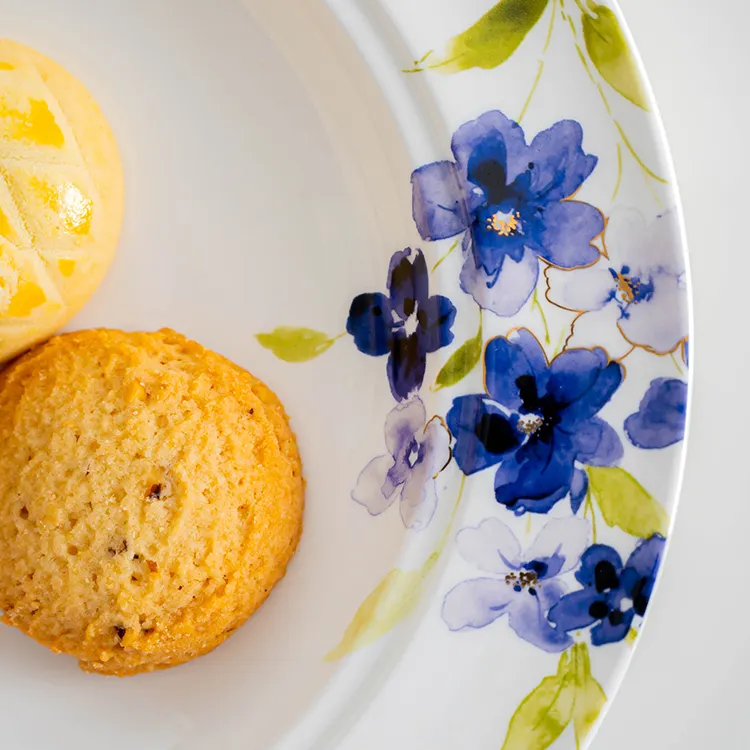 This close-up image highlights the intricate blue floral design on a bone china plate.