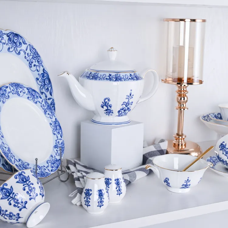 This image showcases a stunning collection of bone china dinnerware, featuring a teapot, plates, cups, and saucers adorned with intricate blue floral patterns.