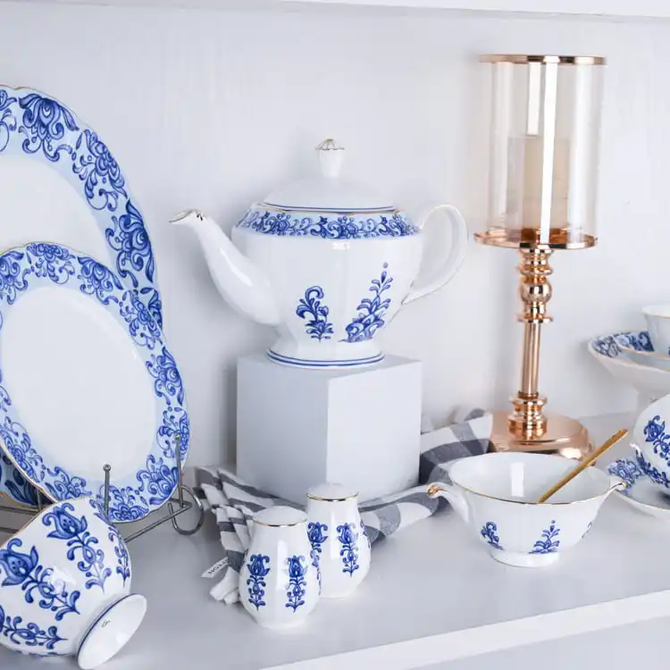 This image showcases a stunning collection of bone china dinnerware, featuring a teapot, plates, cups, and saucers adorned with intricate blue floral patterns.