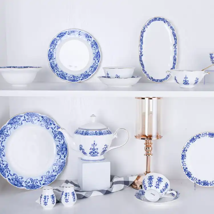 This image displays a comprehensive collection of bone china dinnerware, featuring a variety of plates, bowls, and a teapot, all adorned with exquisite blue floral patterns.