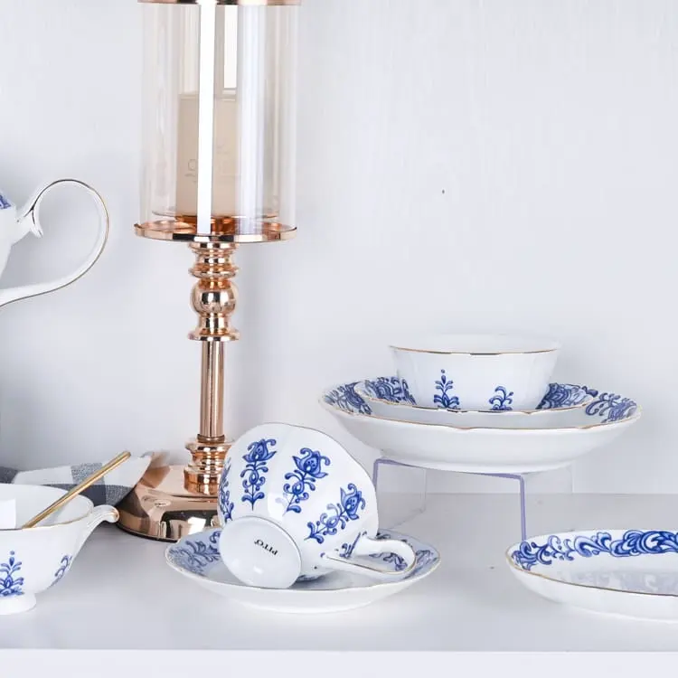 This image presents a refined collection of bone china tableware, including bowls, plates, and cups, all featuring elegant blue floral designs.