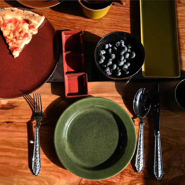 This image showcases a sophisticated dining arrangement featuring colorful glazed porcelain dinnerware.