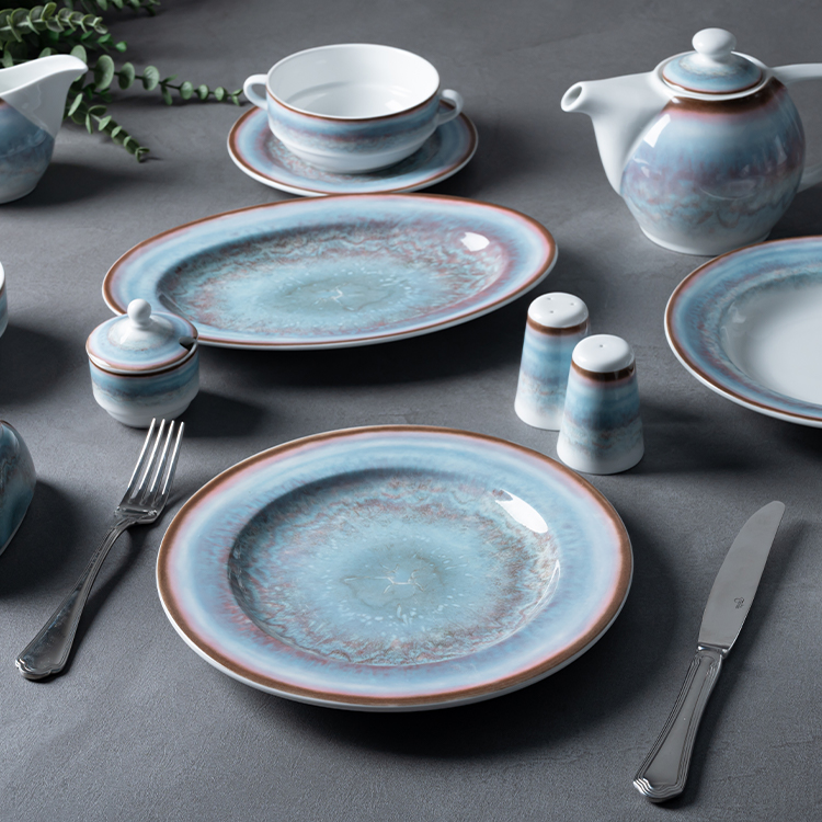 This image features a comprehensive porcelain dining set, including a teapot, a soup bowl with a saucer, an oval serving plate, a dinner plate.