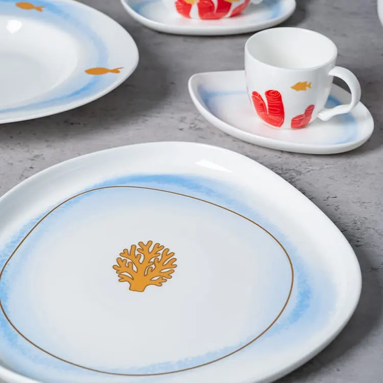 This image focuses on a plate and cup from the Coral Reef Dinnerware set, highlighting the intricate coral design and fine porcelain craftsmanship.