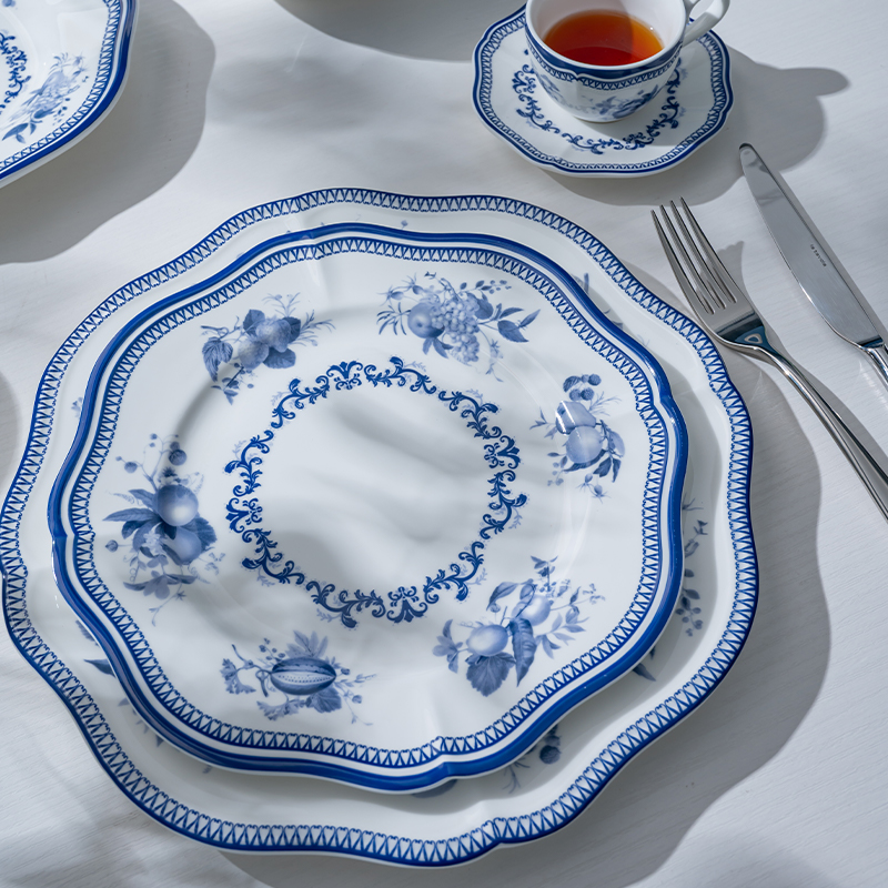 This image captures a beautifully arranged blue flower porcelain dinner setting, featuring plates, a cup, and a saucer.