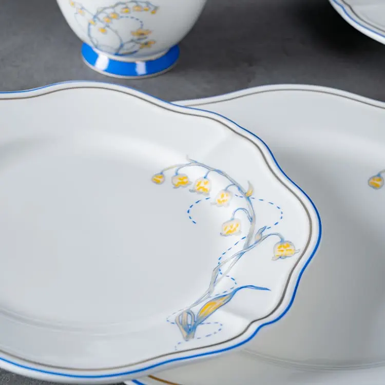 This image showcases a fine porcelain plate adorned with a delicate lily of the valley design.