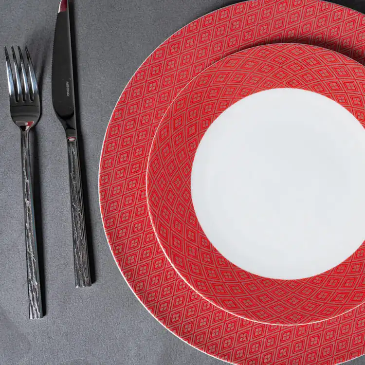 The image provides a close-up view of the red patterned plates from the bone china dinnerware collection.