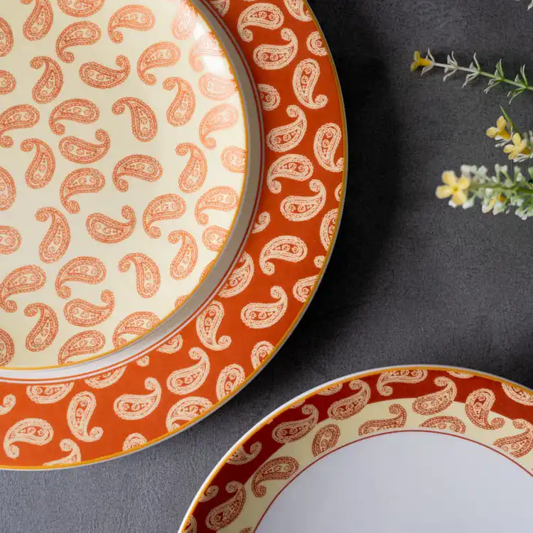 This image highlights the intricate paisley pattern on porcelain plates, showcasing the detailed design work that characterizes this dinnerware set.