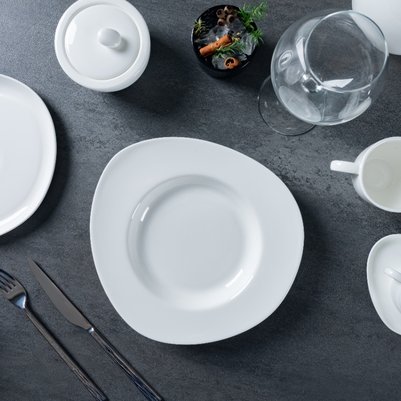 The image presents a sophisticated dining setup featuring a variety of fine porcelain tableware.