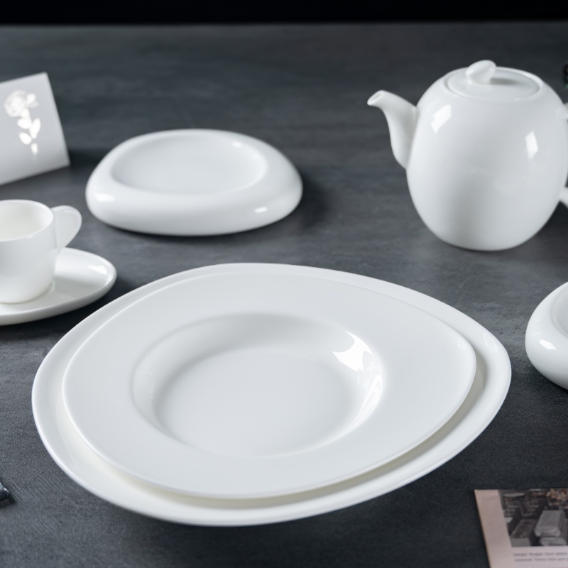 This image showcases a selection of fine porcelain dining ware, including plates, a teapot, and a cup with a saucer.
