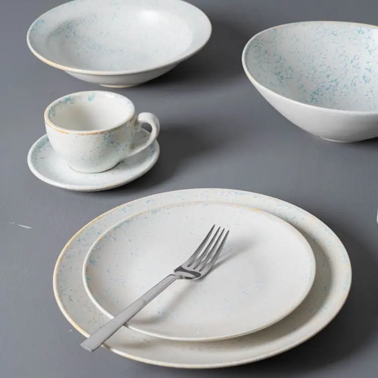 This image presents a sophisticated dining setup featuring a selection of fine porcelain dinnerware, including plates, bowls, and a cup with a saucer.