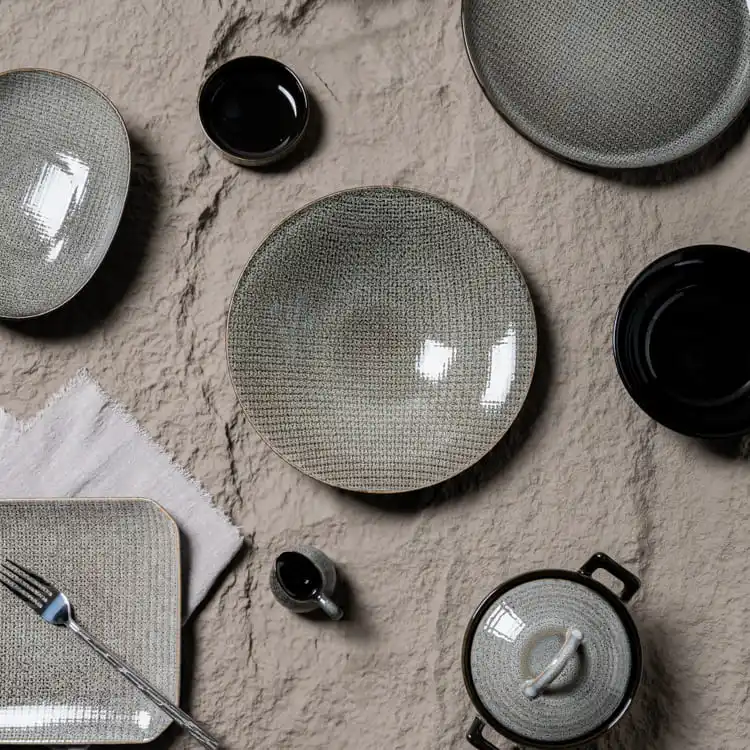 The set includes various plates, bowls, and a small pot, each piece featuring a consistent, intricate pattern that exudes elegance and sophistication.