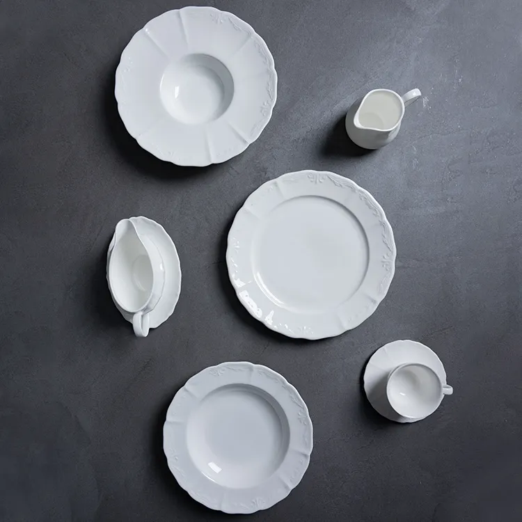 This image features a selection of fine porcelain dinnerware, including plates, a jug, and a bowl, arranged in an aesthetically pleasing manner.