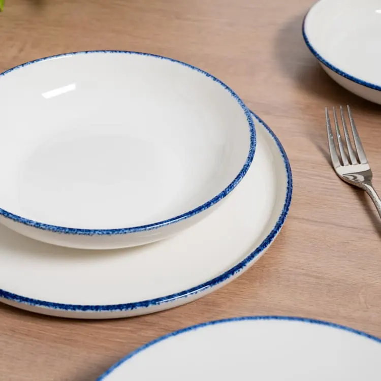 The plates are stacked neatly, highlighting their uniformity and the subtle blue rim that adds a touch of elegance.