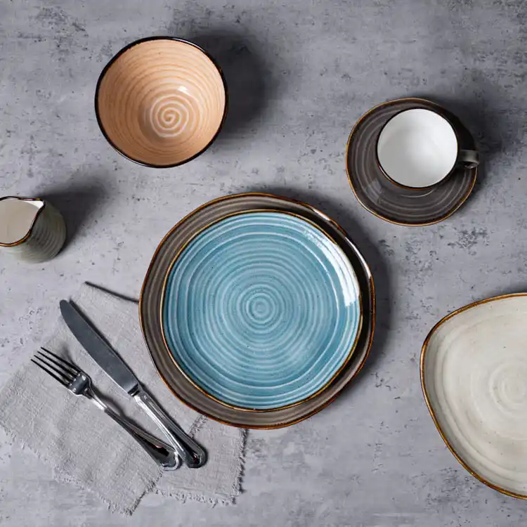 This image showcases an elegant porcelain dining set featuring spiral pattern plates, bowls, and a cup with a saucer.