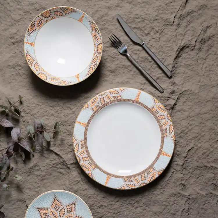 The set includes a dinner plate and a smaller plate, complemented by a fork and knife, all placed on a textured surface.