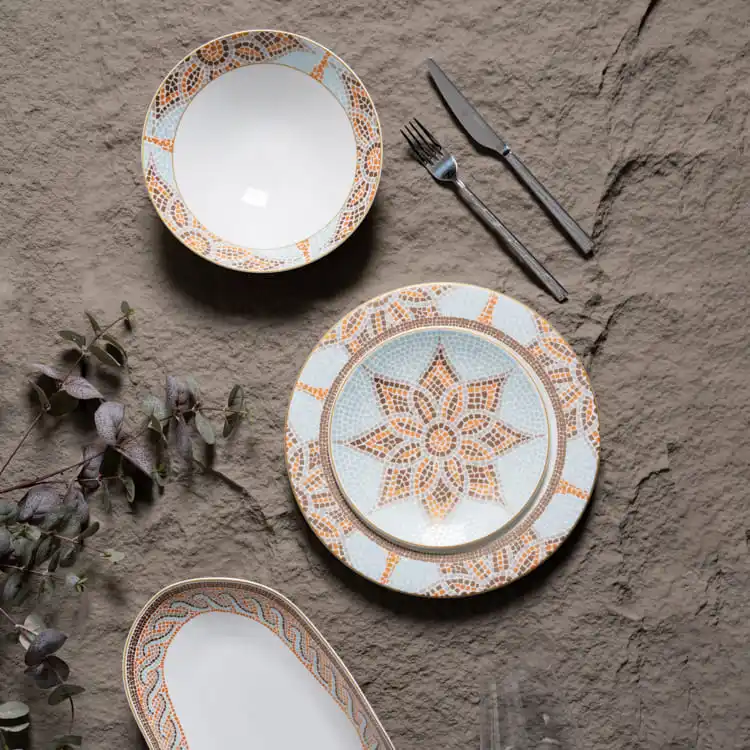 The set includes a dinner plate and a smaller plate, complemented by a fork and knife, all placed on a textured surface.