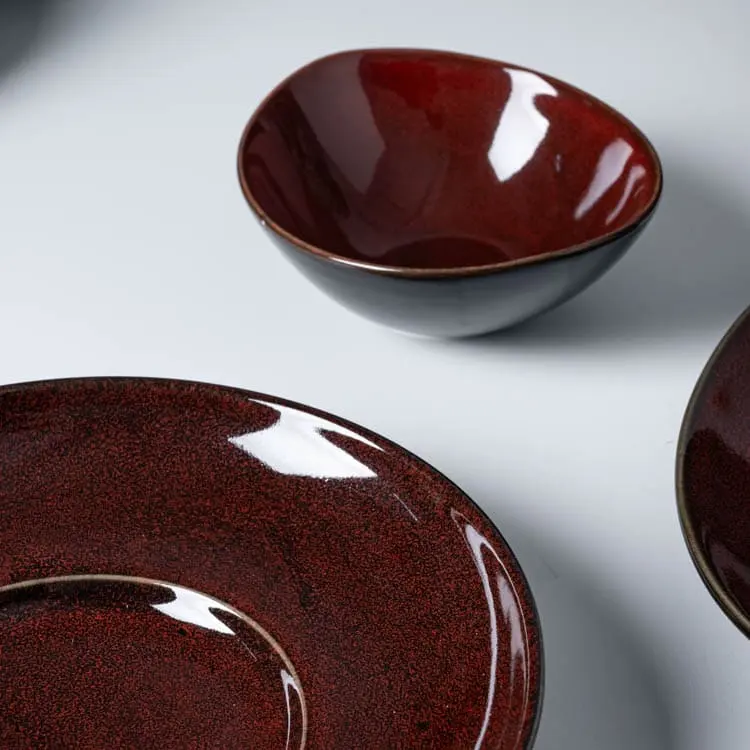 This image features a bowl and plate from the crimson red porcelain dish set, emphasizing their harmonious design and rich color.