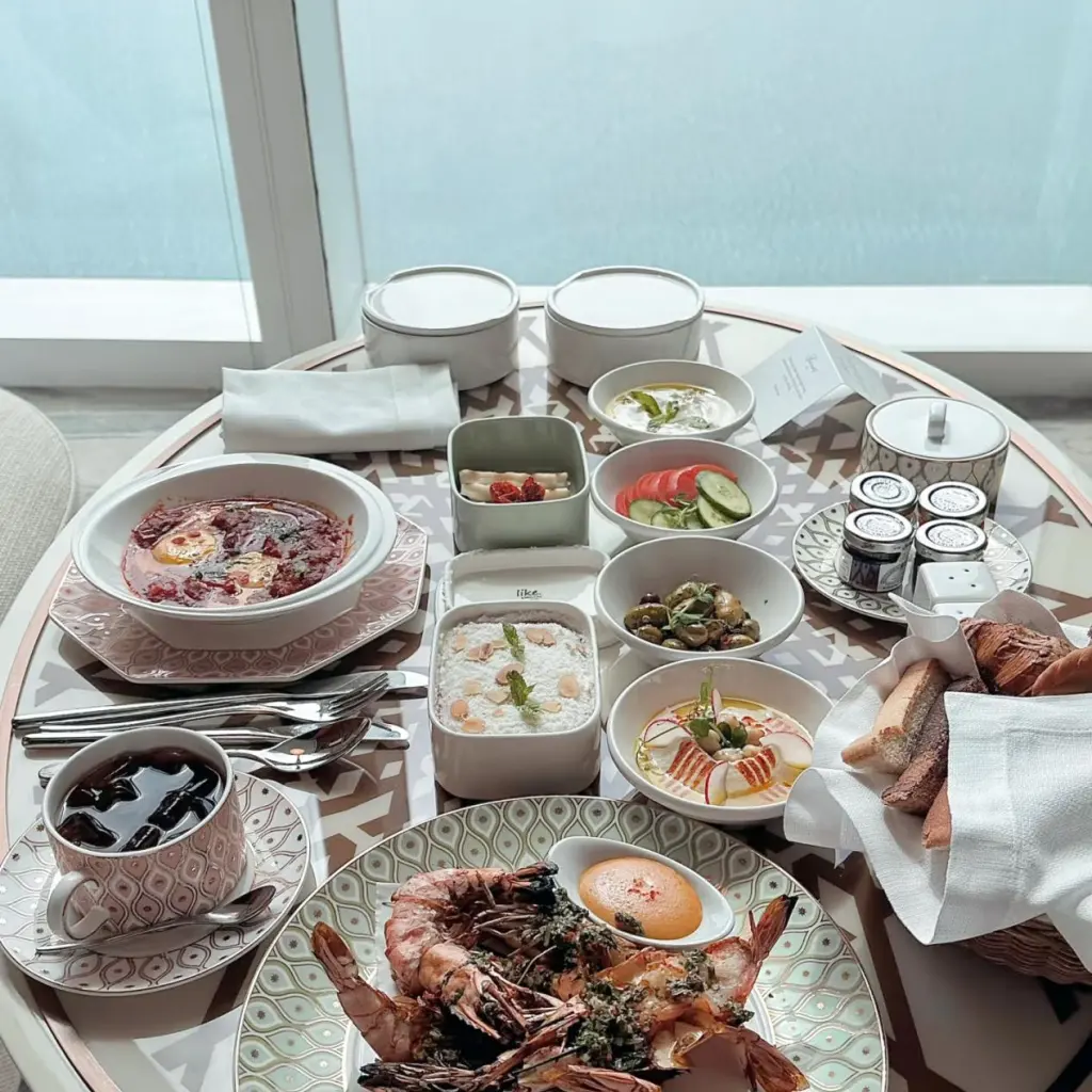 Complete private in-room dining spread at Fairmont Doha, featuring seafood, Arabic dips and soups served on exclusive bespoke patterned bone china tableware for hotel guests.