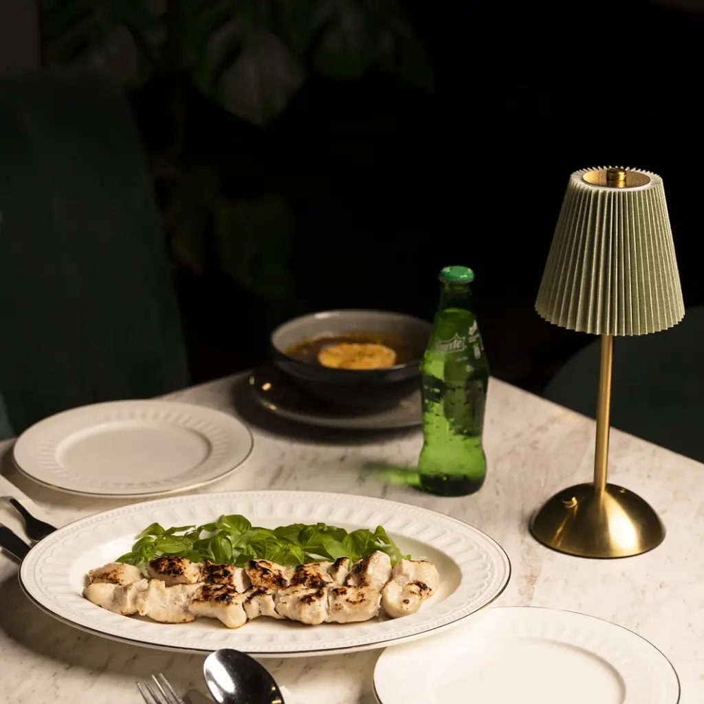 Grilled chicken skewers served on a PITO Roman Gold Edge bone china platter under cozy table lighting.