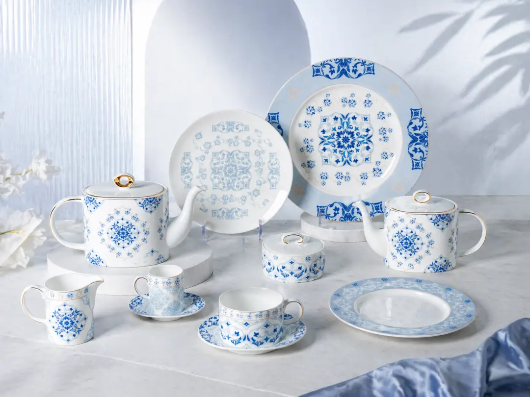 Blue and white fine porcelain dinnerware collection displayed on white pedestals in studio setting