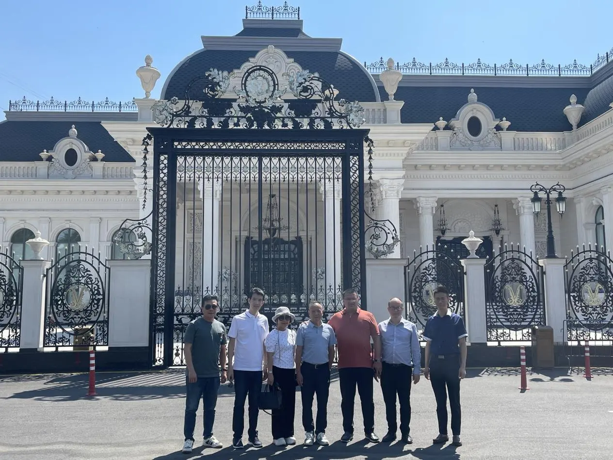 PITO staff and clients posing for a group photo in front of the grand entrance gate of the luxurious Versal venue.