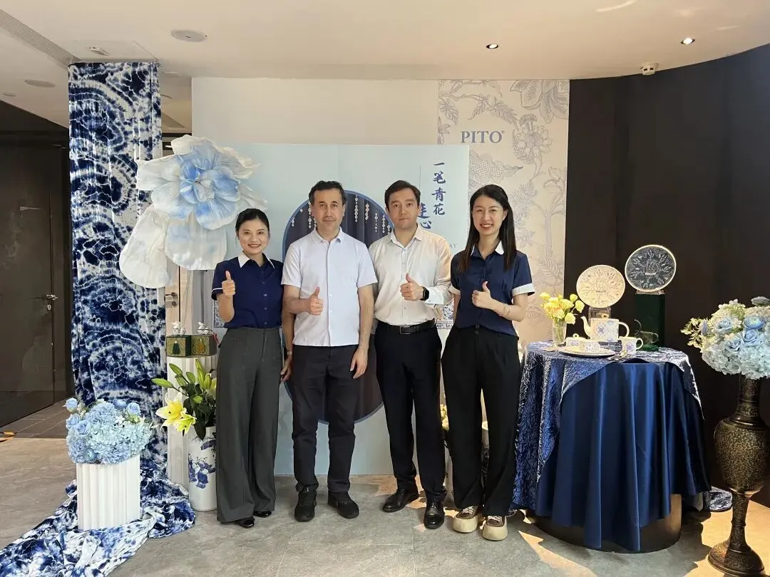 Group photo of Uzbekistan Commercial Consul, accompanying officer and PITO core team at blue-and-white porcelain themed exhibition stand, all thumbs-up for cooperation.