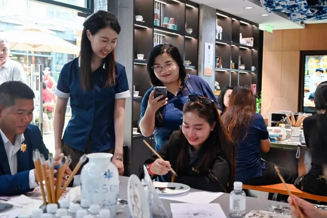 Guests try hands-on porcelain painting during the Chaozhou heritage workshop.