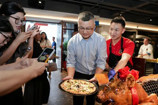 Guests take photos as Neapolitan pizza and roasted pig are served on PITO plates.