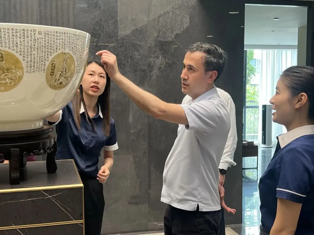 Consul carefully observes the huge hand-painted literary porcelain bowl, PITO staff explains Chaozhou blue-and-white porcelain carving and painting craft details.